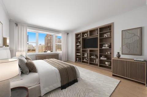 a bedroom with a bed a dresser and a large window