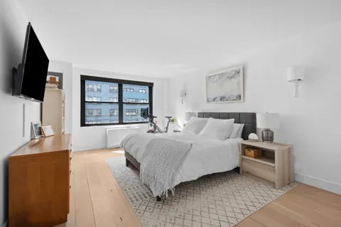 a spacious bedroom with a large bed and a flat screen tv