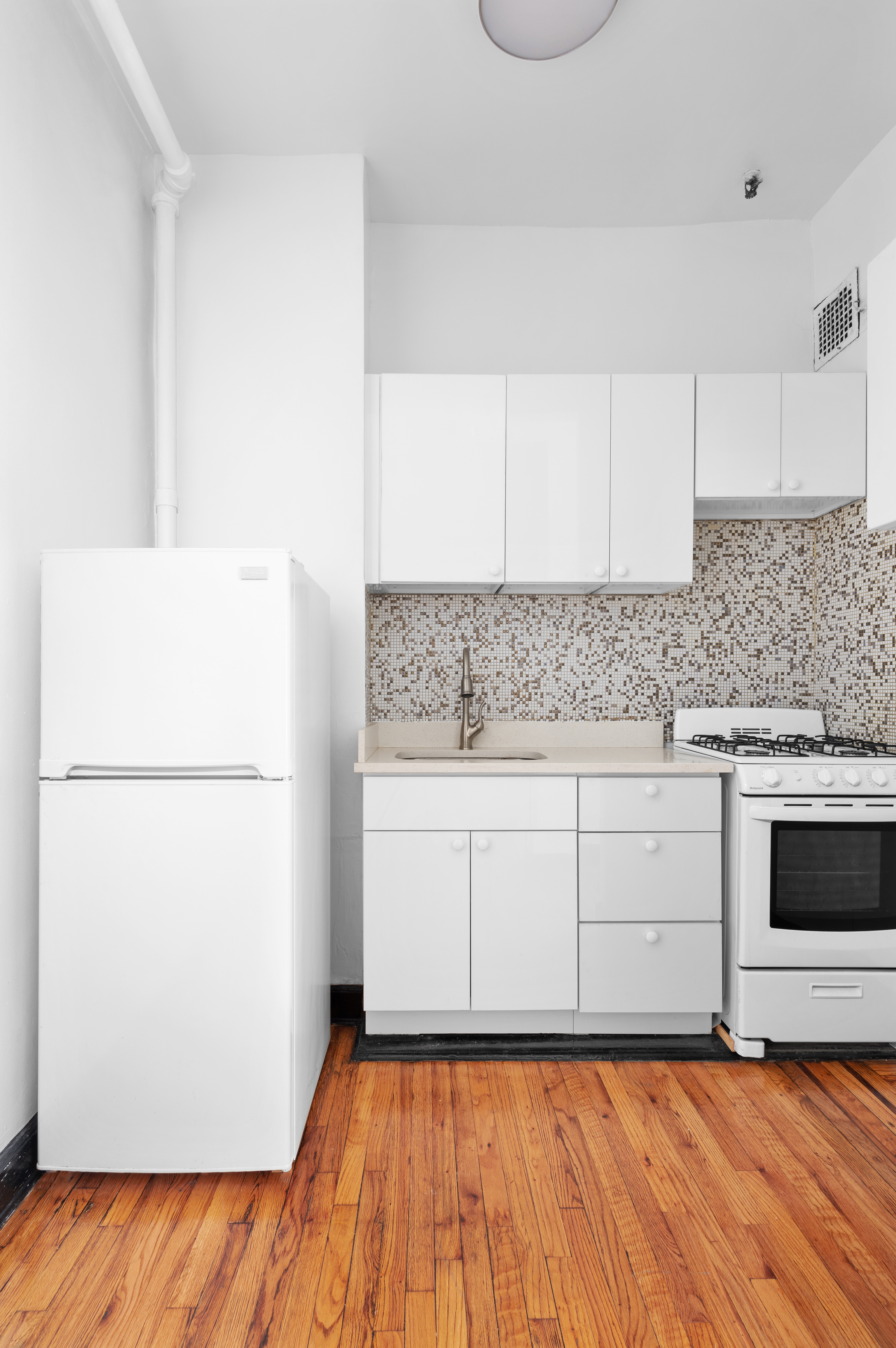 305 East 12th Street, Unit PARLOR Manhattan, NY 10003 - Photo 4 of 5 a kitchen with a refrigerator sink stove and cabinets