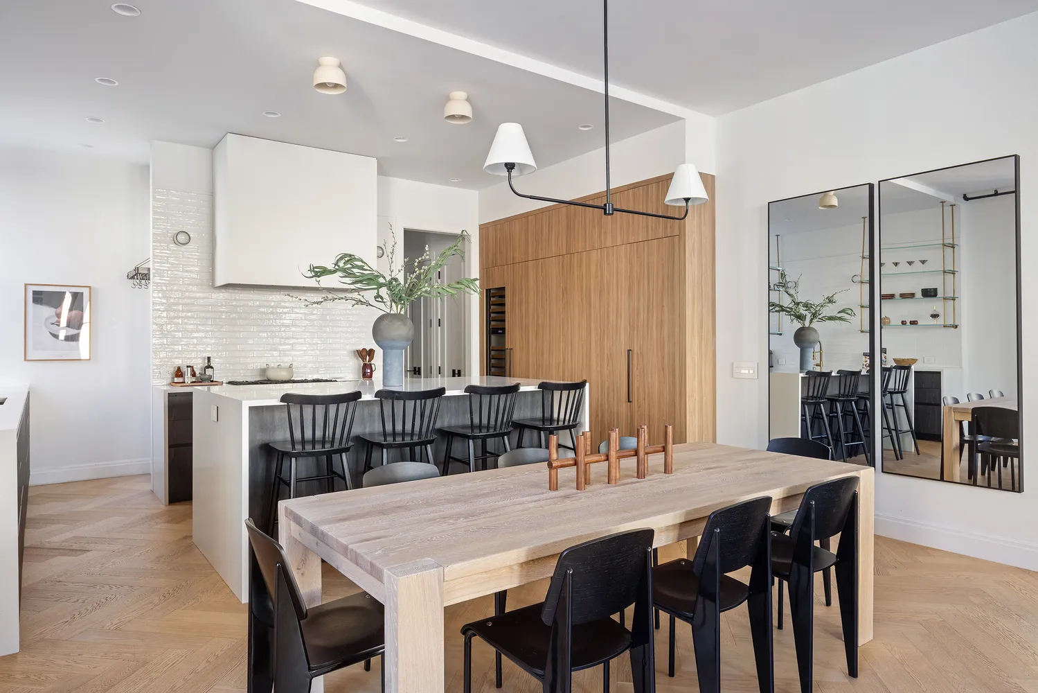 a kitchen with stainless steel appliances granite countertop a dining table chairs and white cabinets