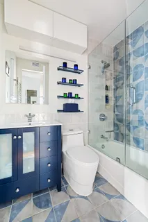 a spacious bathroom with a bathtub shower sink mirror and toilet
