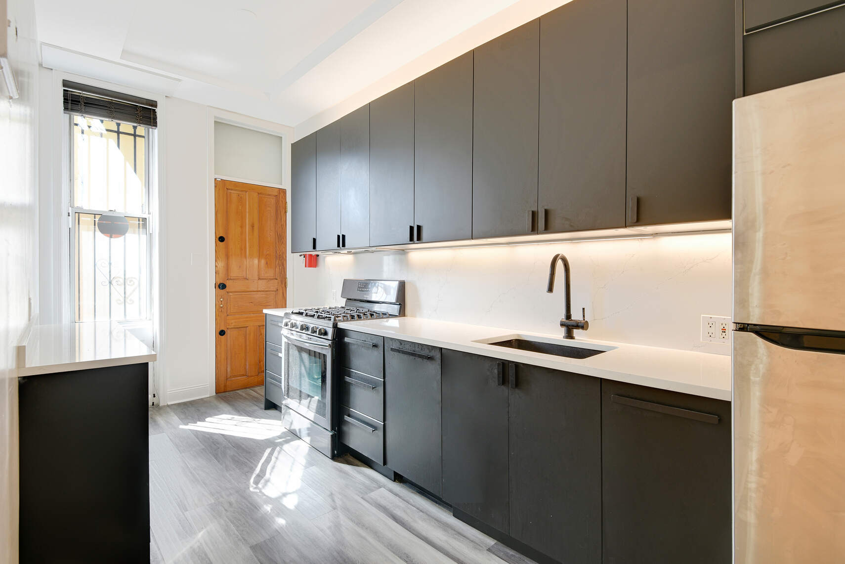 514 Hart Street, Unit PARLOR Brooklyn, NY 11221 - Photo 3 of 9 a kitchen with stainless steel appliances a sink cabinets and a refrigerator