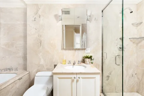 a bathroom with a granite countertop sink toilet and shower