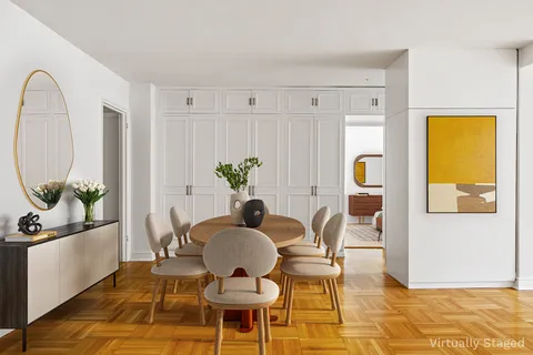 a dining room with furniture a rug a potted plant and a chandelier