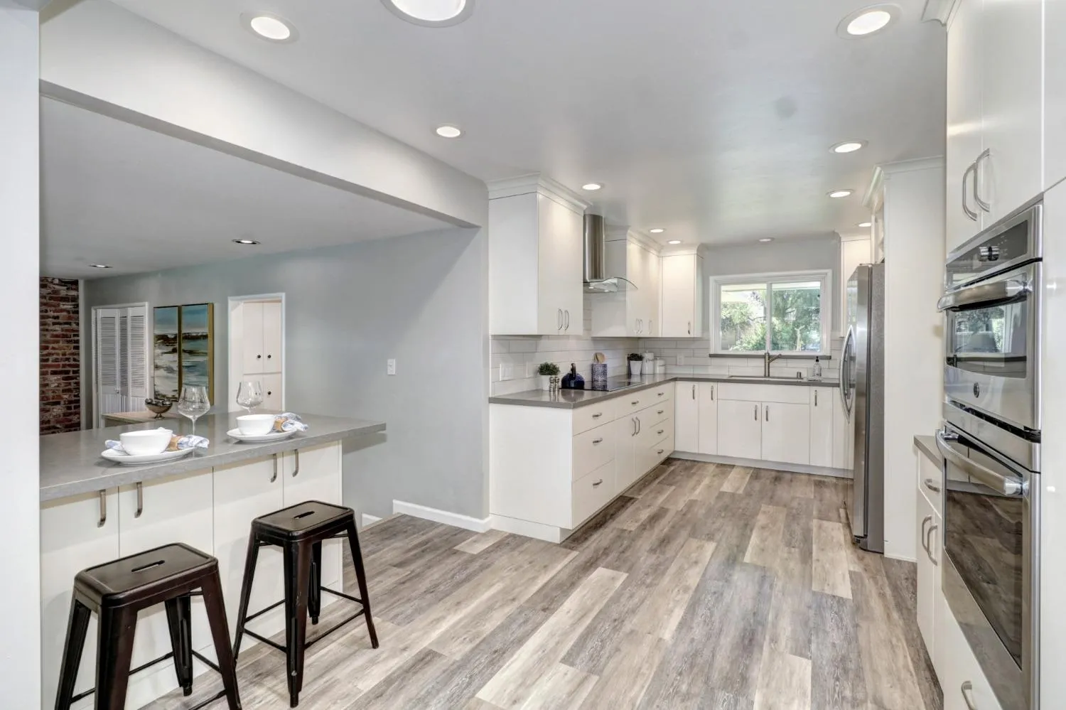 a large kitchen with cabinets wooden floor and stainless steel appliances