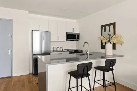 a kitchen with stainless steel appliances granite countertop a sink and a refrigerator