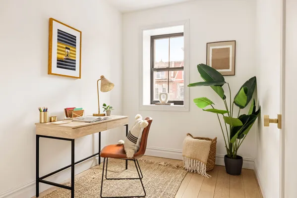 a view of a workspace with furniture and a potted plant