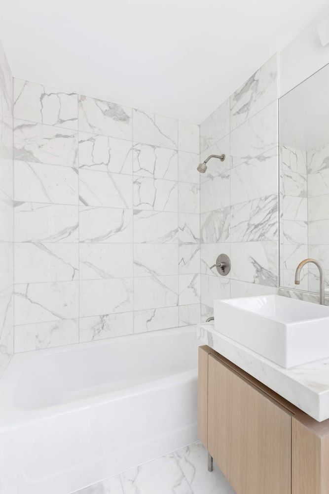 250 East 53rd Street, Unit 1001 Manhattan, NY 10022 - Photo 11 of 18 a bathroom with a sink and a bathtub