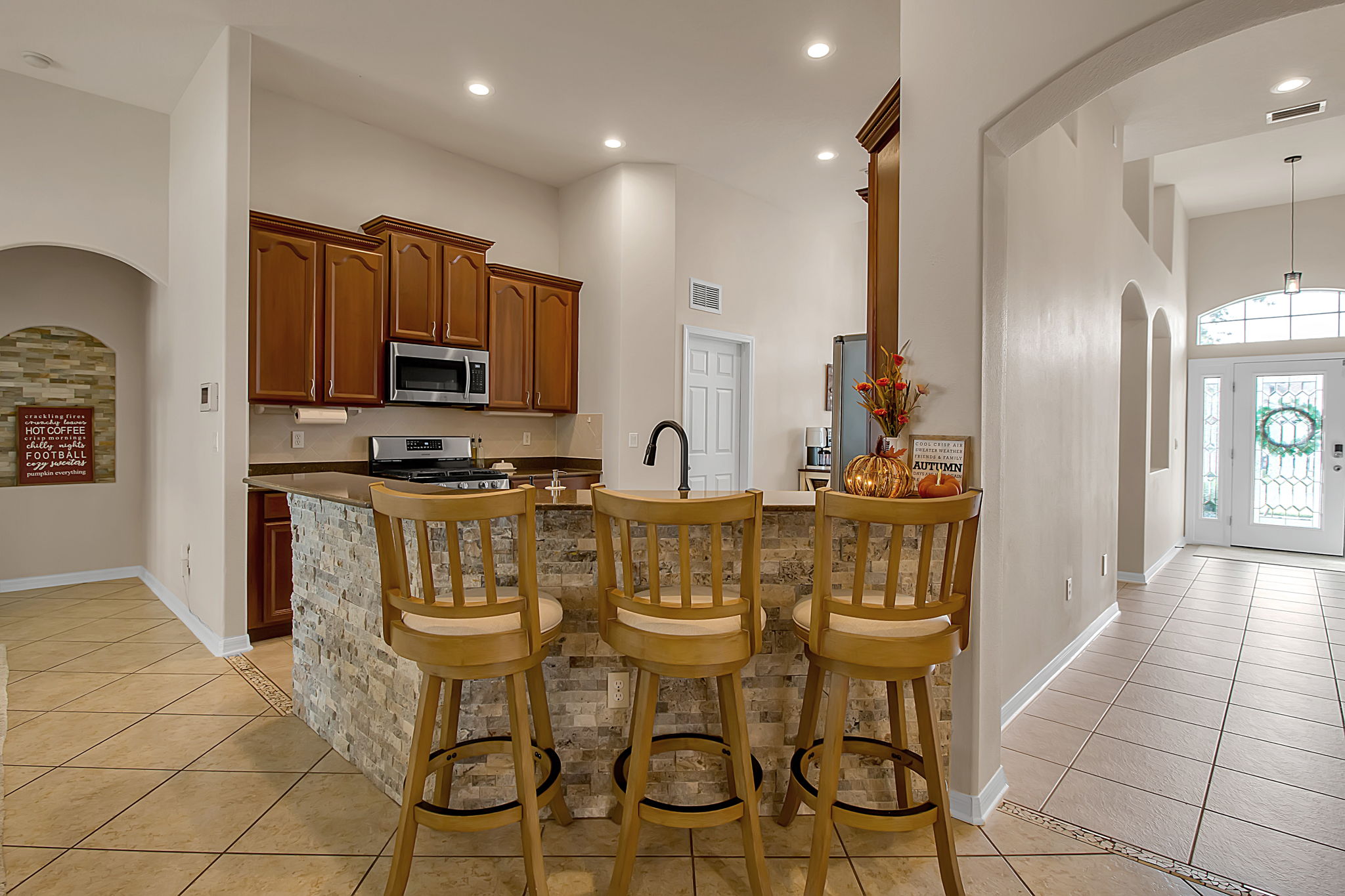 6106 34th Court East Bradenton, FL 34203 - Photo 28 of 69 a kitchen with stainless steel appliances kitchen island granite countertop a refrigerator and microwave