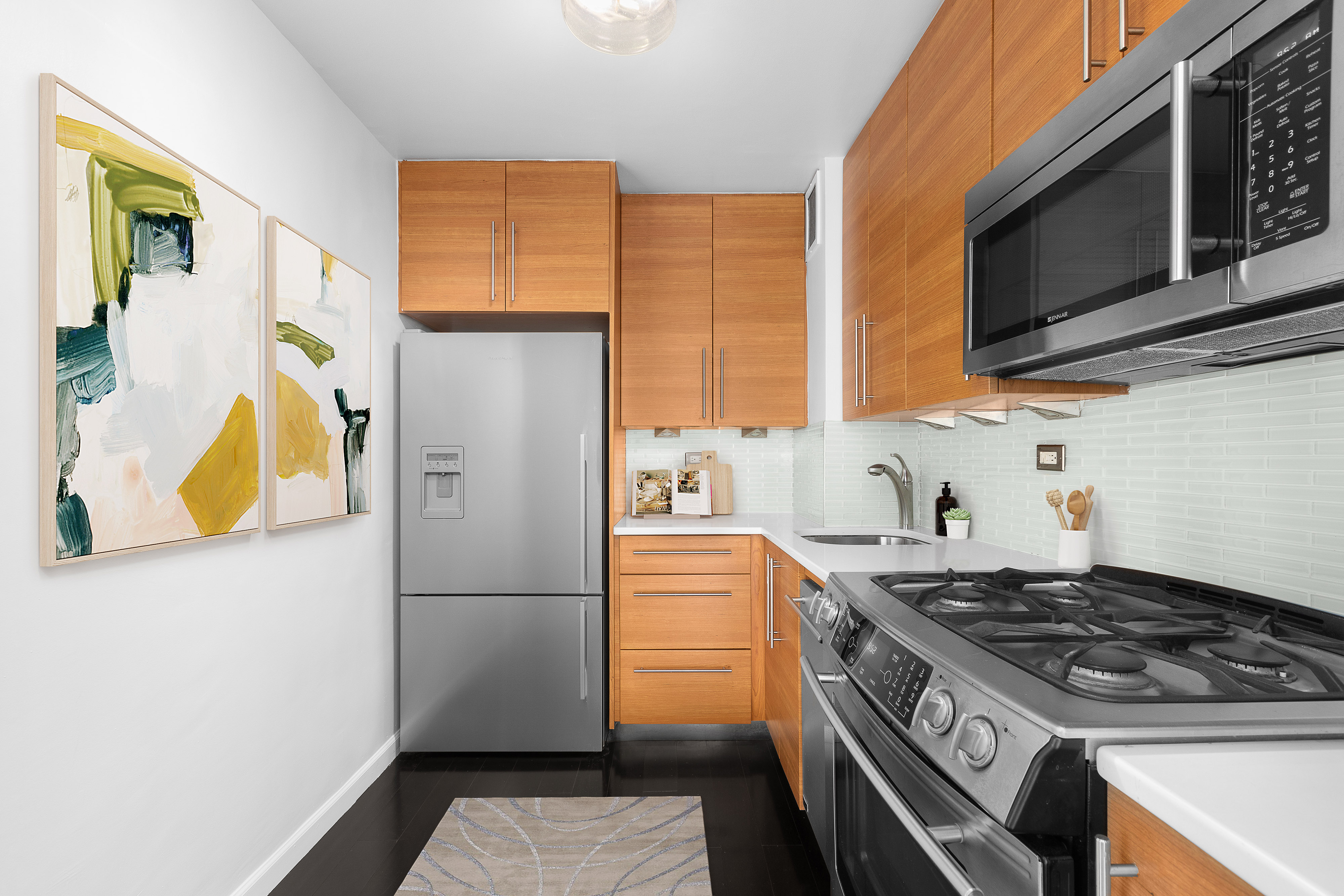 10 West 15th Street, Unit 1721 Manhattan, NY 10011 - Photo 5 of 10 a kitchen with stainless steel appliances granite countertop a refrigerator and a stove