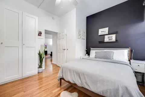 a spacious bedroom with a bed and a wooden floor