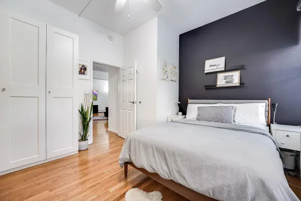 a spacious bedroom with a bed and a wooden floor