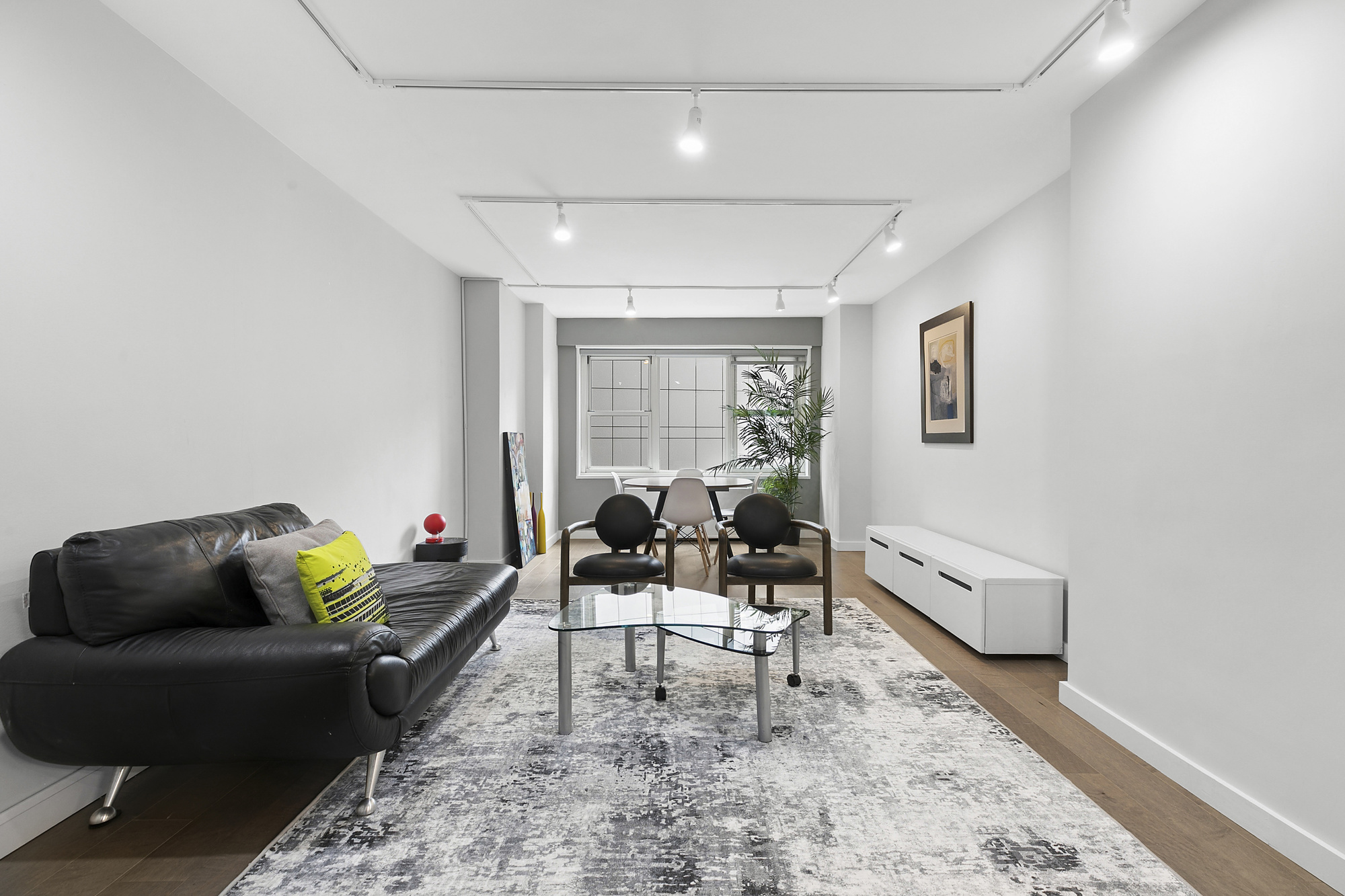 159 West 53rd Street, Unit 11D Manhattan, NY 10019 - Photo 1 of 9 a living room with furniture and wooden floor