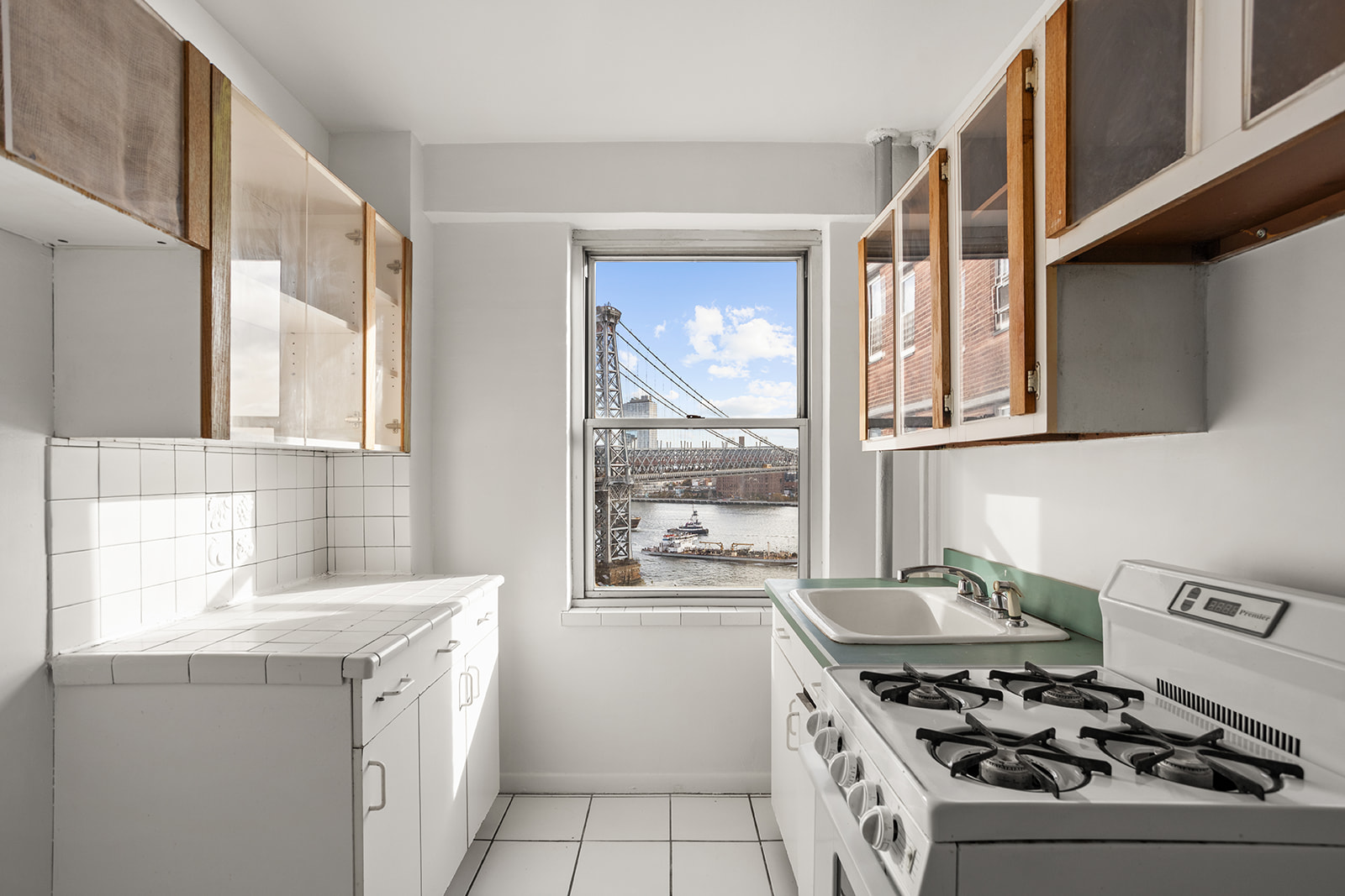 473 FDR Drive, Unit K1401 Manhattan, NY 10002 - Photo 5 of 11 a kitchen with a stove a sink and a window