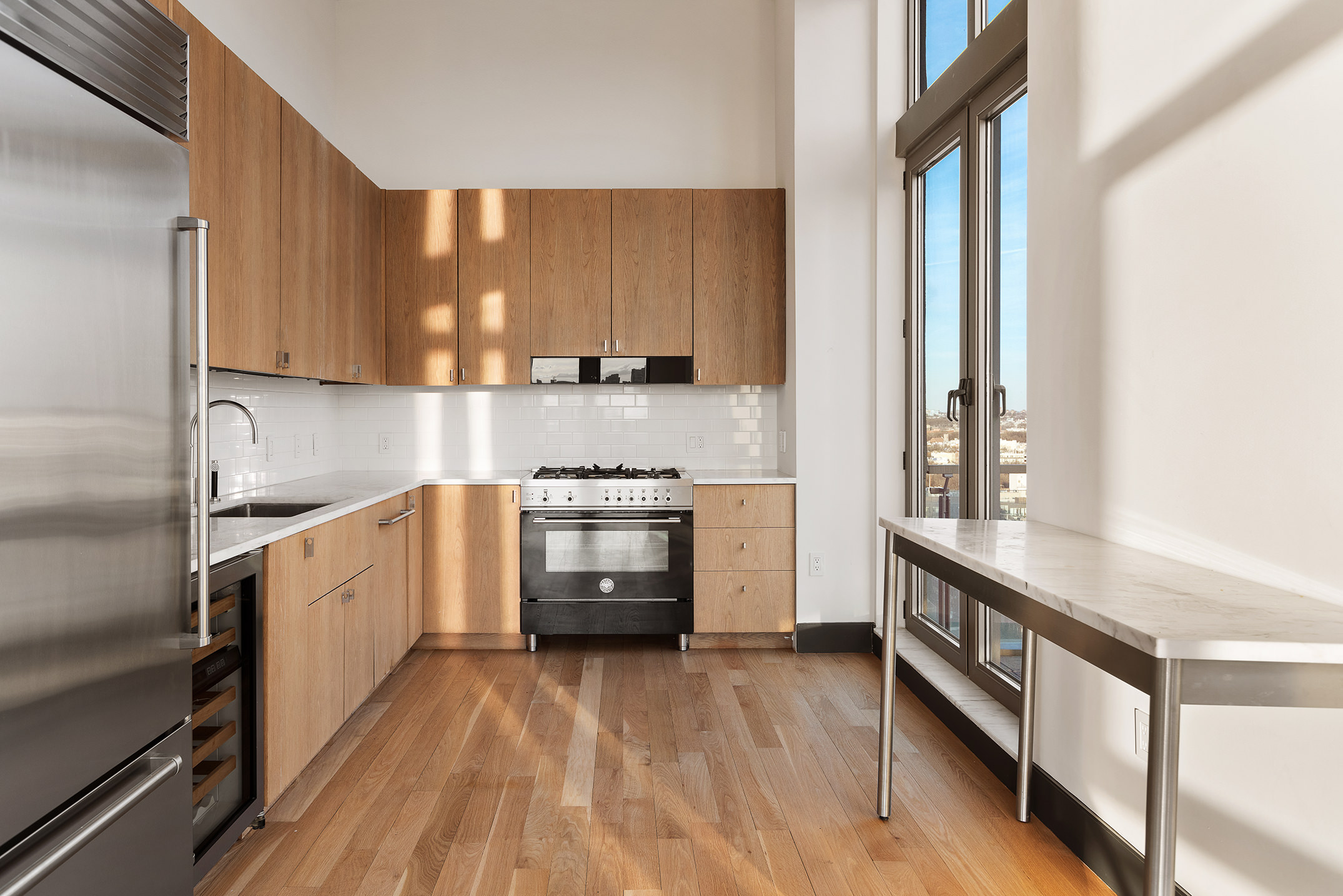 144 North 8th Street, Unit PH2 Brooklyn, NY 11249 - Photo 4 of 20 a kitchen with stainless steel appliances a sink a stove and a refrigerator
