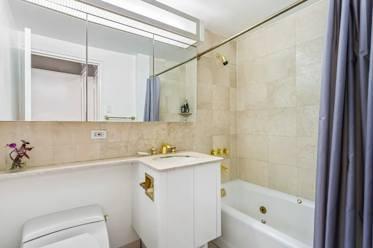 20 East 68th Street, Unit 11B Manhattan, NY 10065 - Photo 6 of 10 a bathroom with a sink a toilet and a bathtub