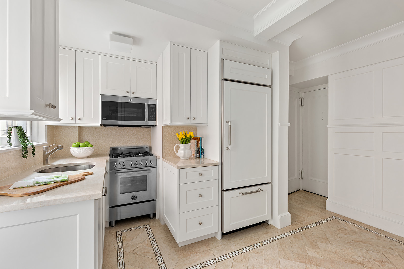 71 East 77th Street, Unit 8A Manhattan, NY 10075 - Photo 2 of 9 a kitchen with white cabinets and stainless steel appliances