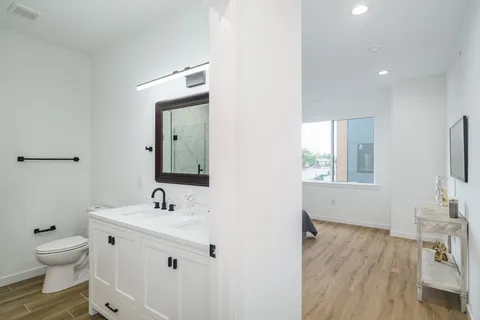 a bathroom with a toilet sink a mirror and vanity