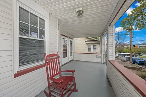 a view of a porch with furniture and floor to ceiling window