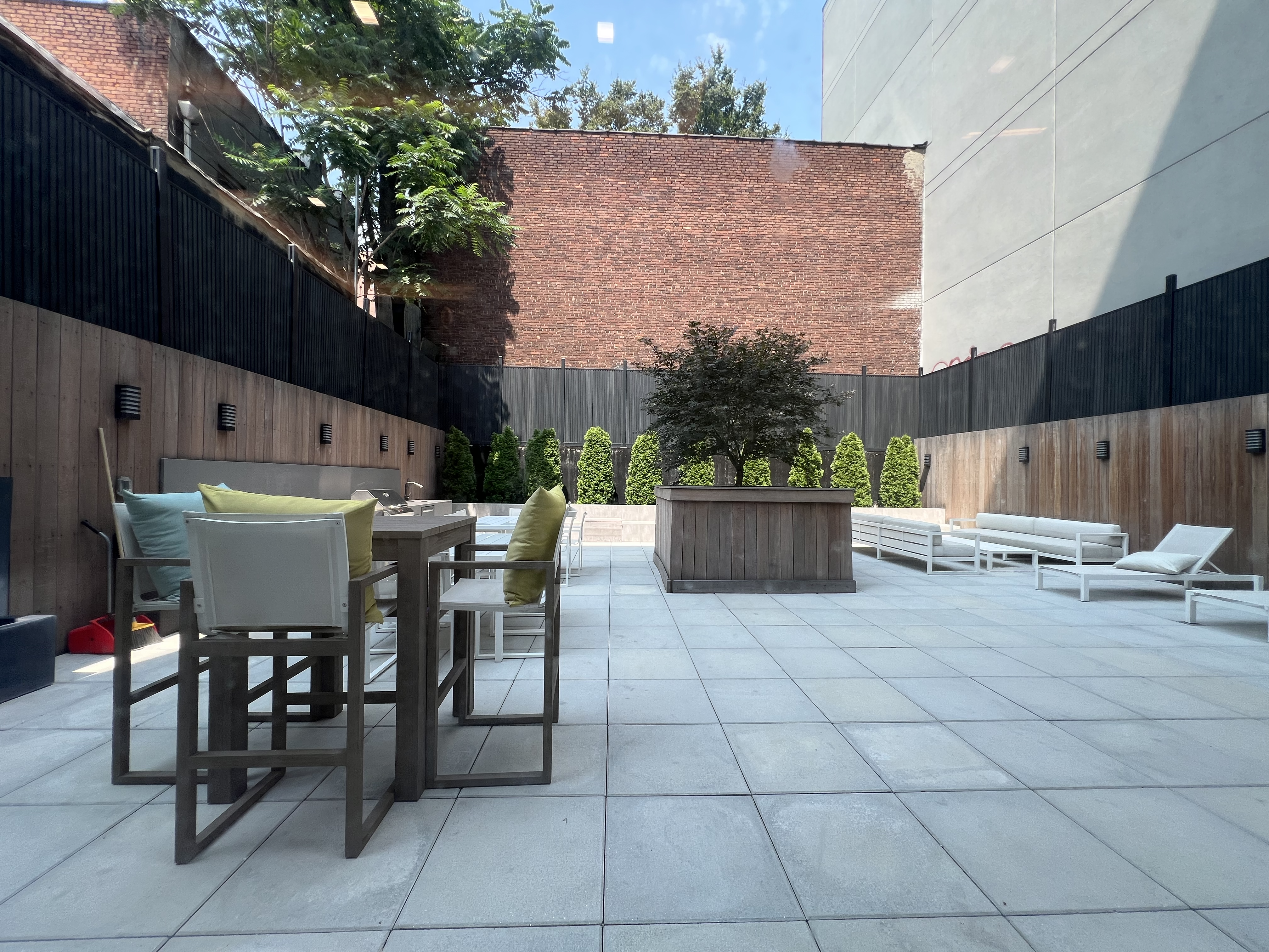 37-34 33rd Street, Unit 7H Queens, NY 11101 - Photo 16 of 18 a view of a patio with a table and chairs and potted plants