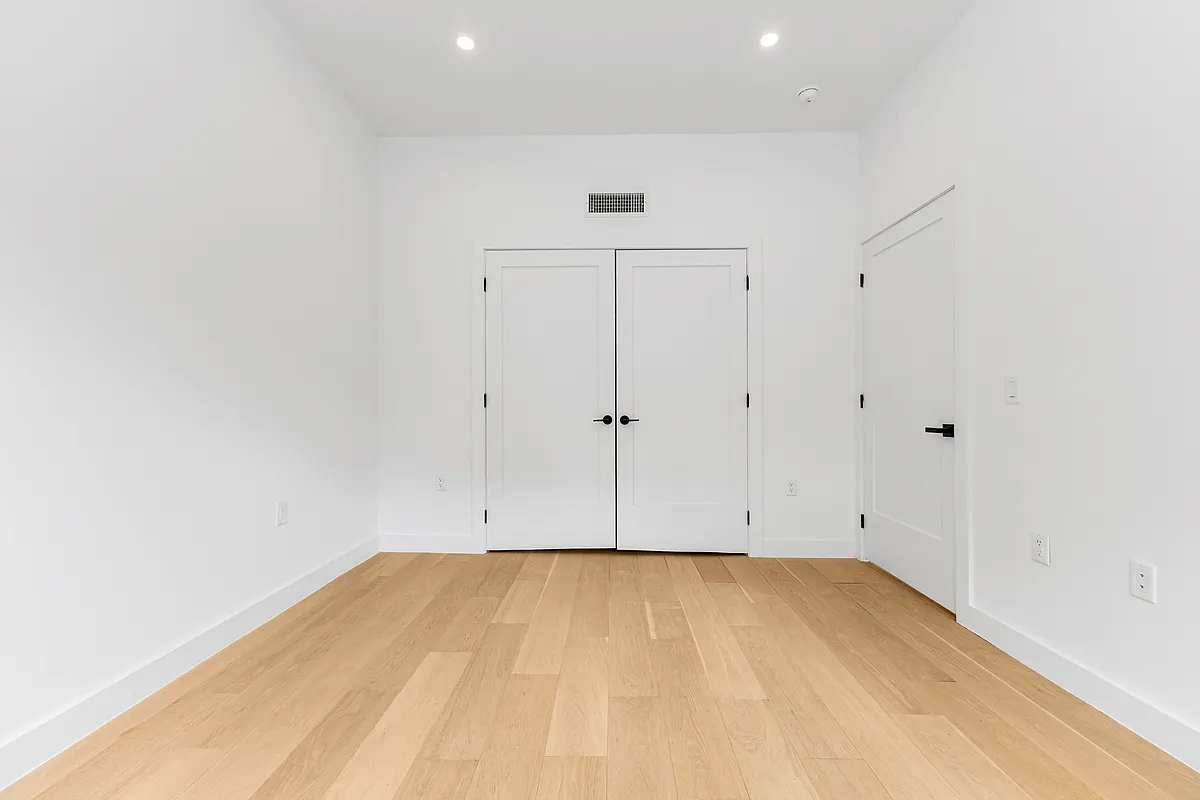 21-10 30th Avenue, Unit 1R Queens, NY 11102 - Photo 6 of 16 an empty room with wooden floor