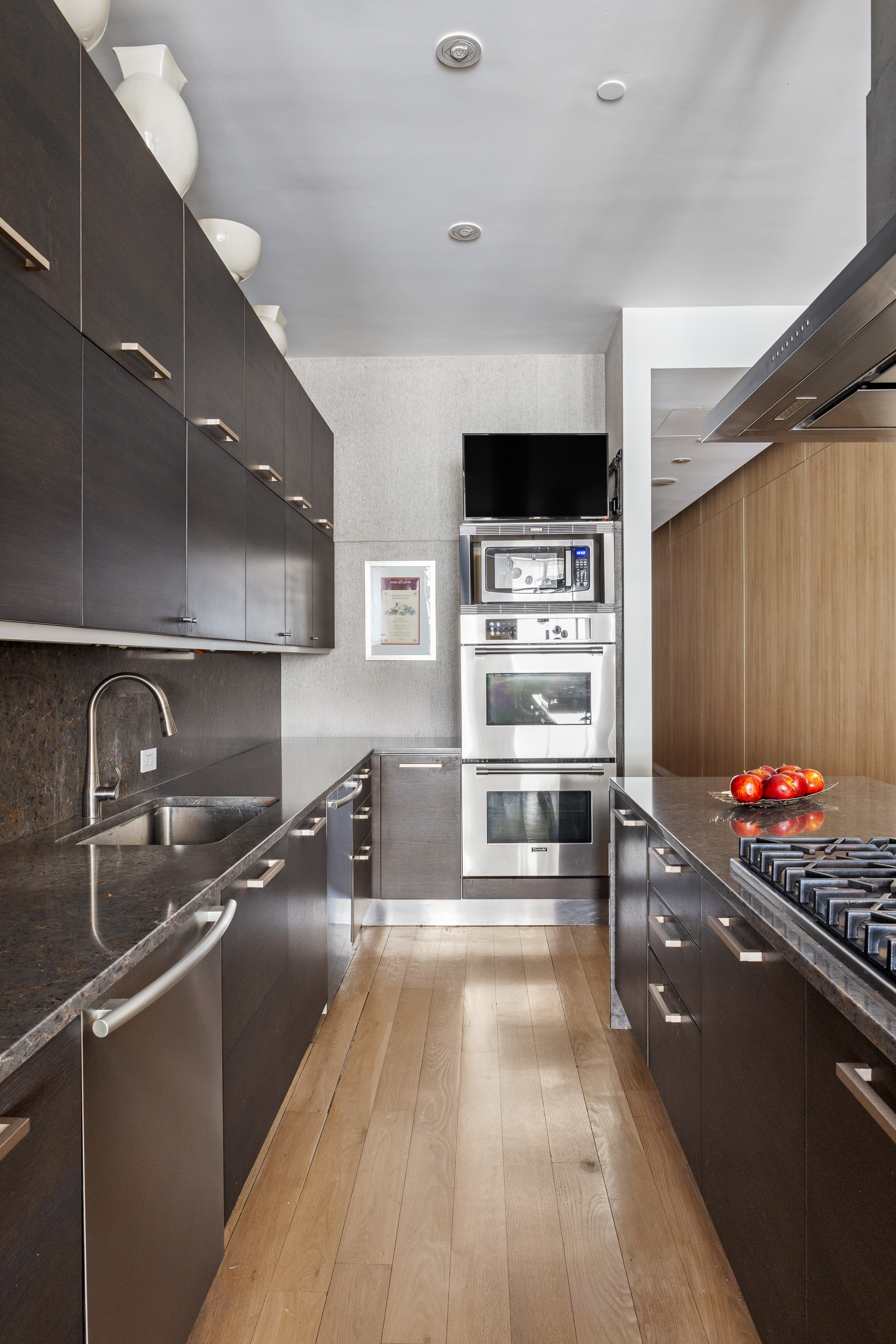 157 East 84th Street, Unit THA Manhattan, NY 10028 - Photo 12 of 33 a kitchen with stainless steel appliances kitchen island granite countertop a stove and a sink with cabinets