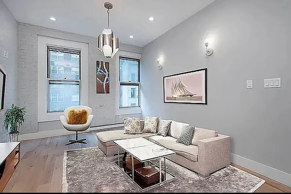 a living room with furniture a dining table and paintings on the wall