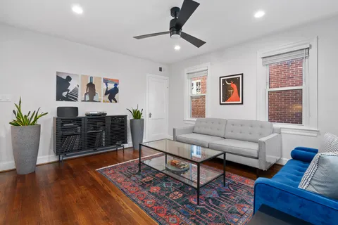 a living room with furniture and a wooden floor