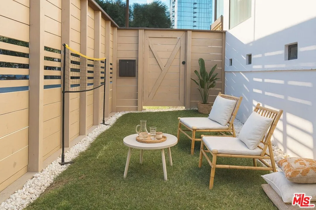 a view of a patio with lawn chairs floor to ceiling window and potted plants
