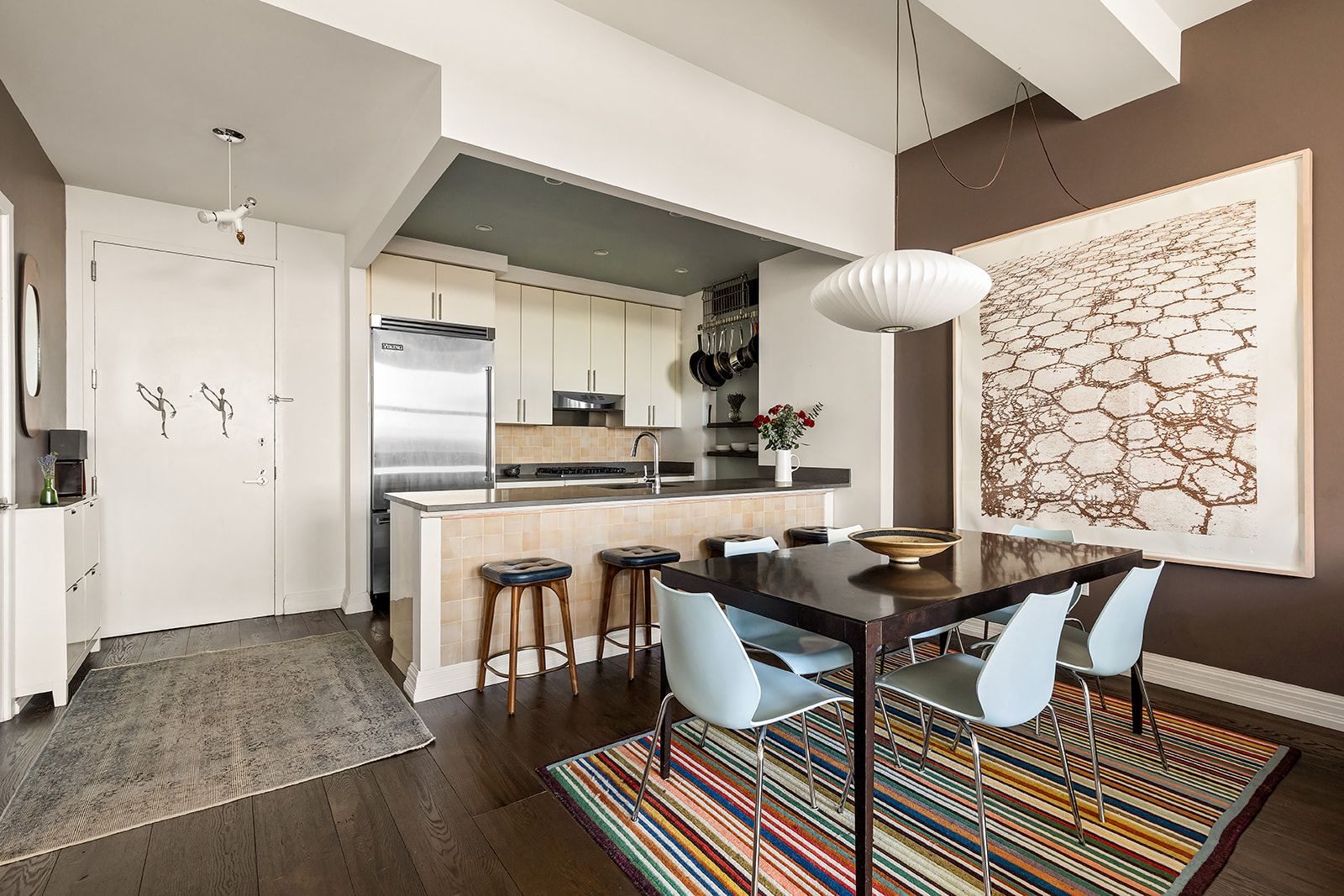 1 Hanson Place, Unit 11J Brooklyn, NY 11243 - Photo 2 of 10 a kitchen with a table chairs refrigerator and wooden cabinets