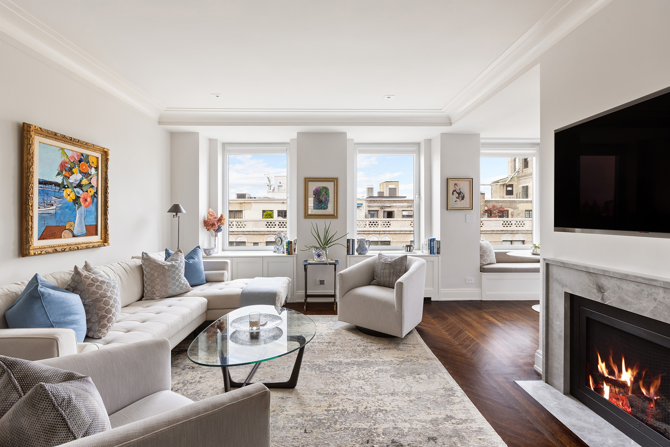 49 East 86th Street, Unit 17B Manhattan, NY 10028 - Photo 1 of 11 a living room with furniture a flat screen tv and a fireplace