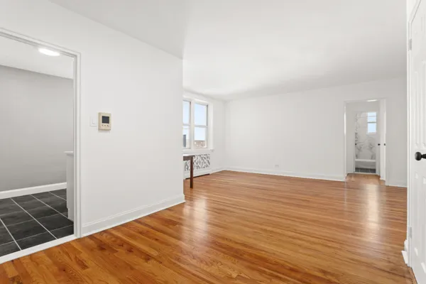 a view of empty room with wooden floor