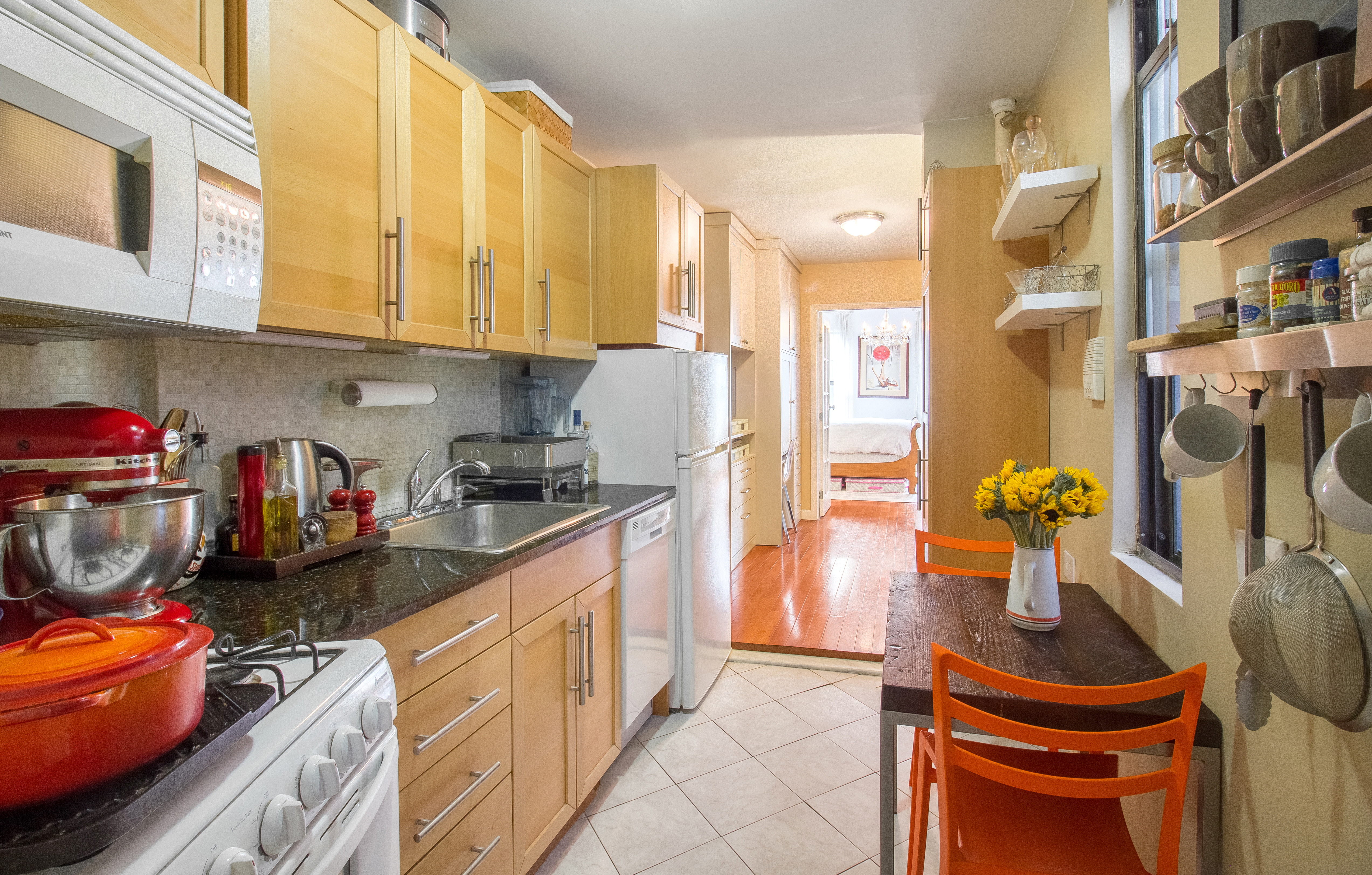 246 East 90th Street, Unit 5C Manhattan, NY 10128 - Photo 5 of 13 a kitchen with stainless steel appliances a sink cabinets and a window
