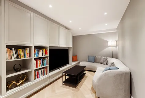 a living room with furniture and a book shelf