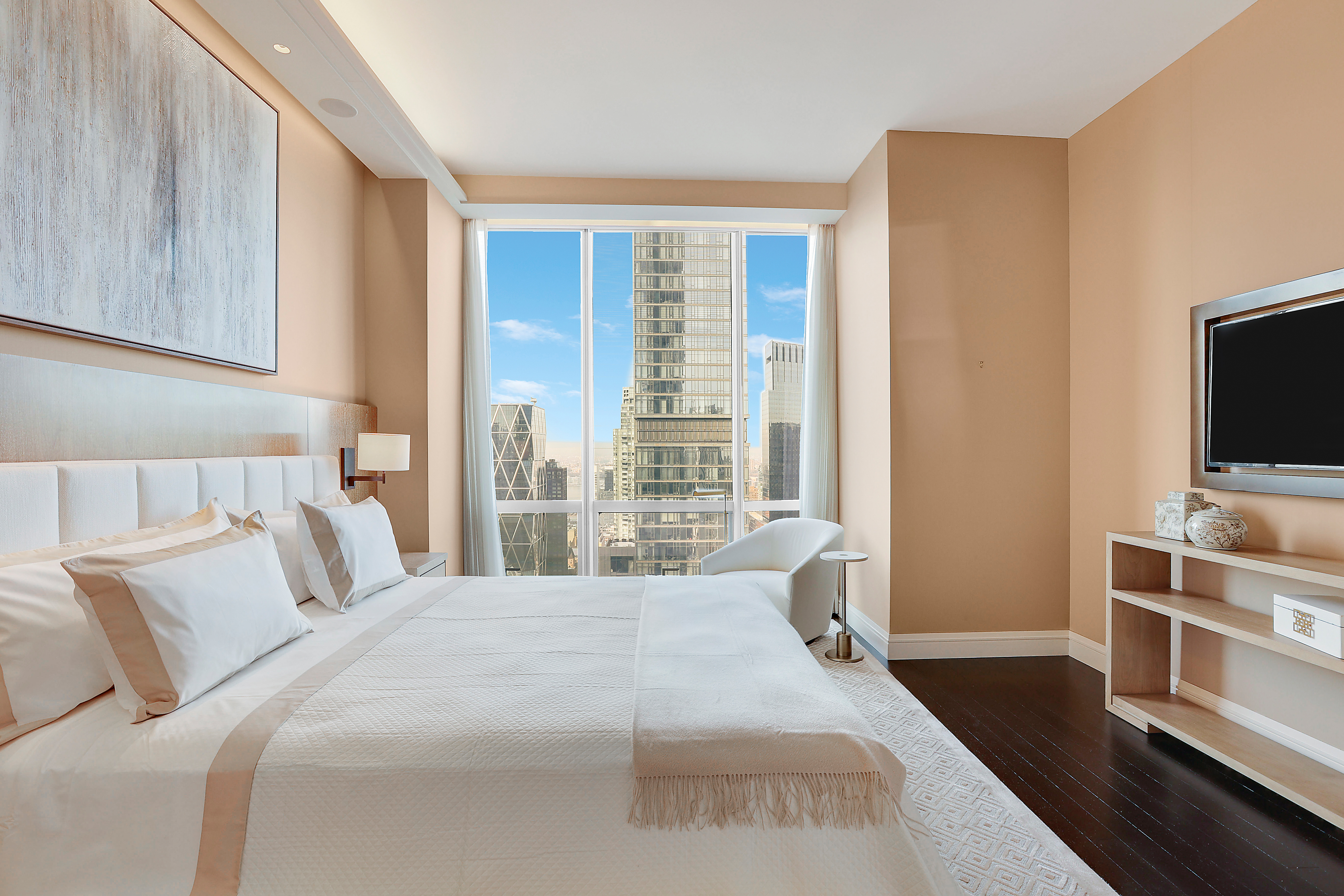 157 West 57th Street, Unit 51A Manhattan, NY 10019 - Photo 5 of 15 a bedroom with a bed and a flat tv screen on dresser