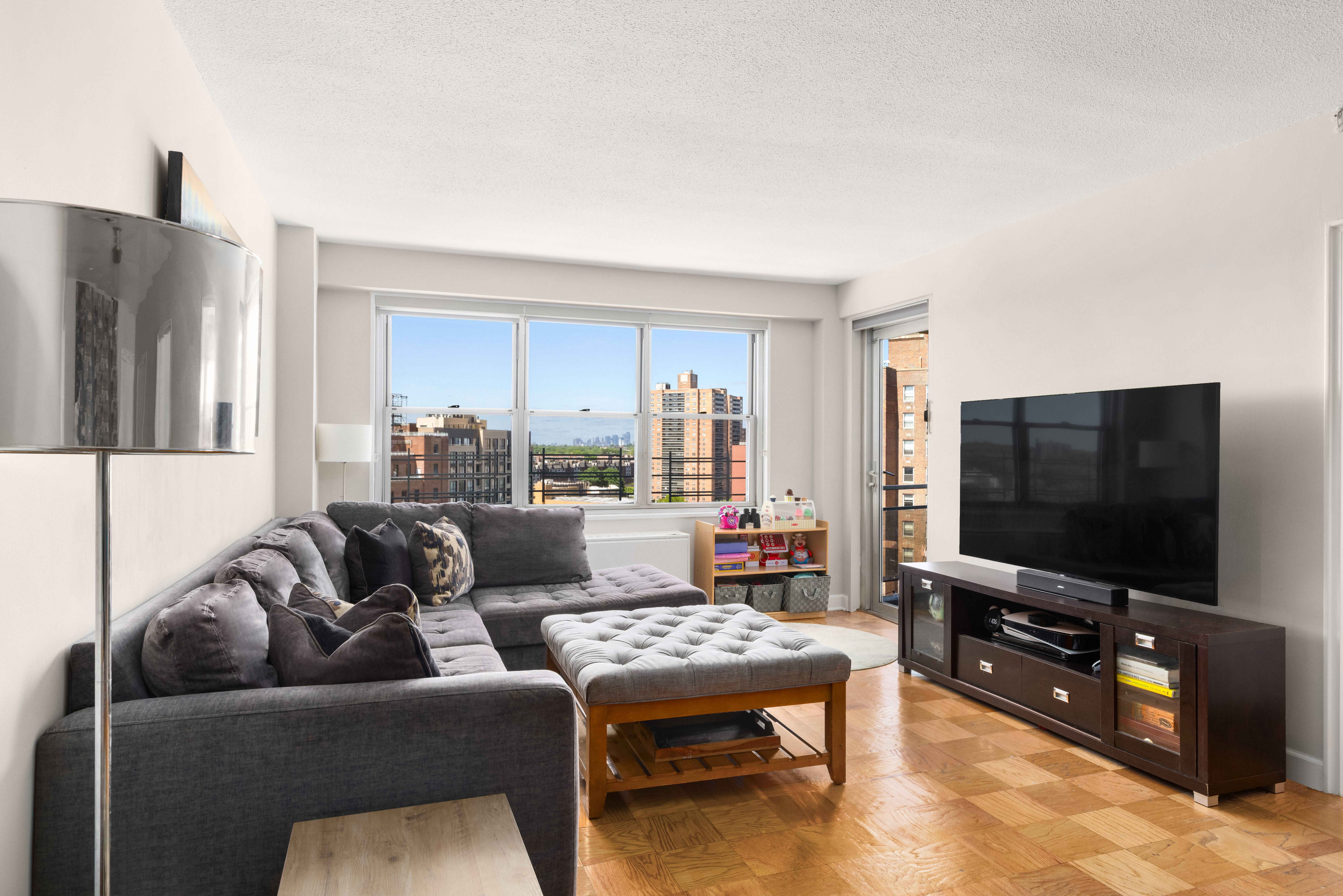 70-31 108th Street, Unit 12D Queens, NY 11375 - Photo 3 of 16 a living room with furniture and a flat screen tv