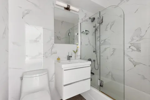 a bathroom with a sink a toilet and shower