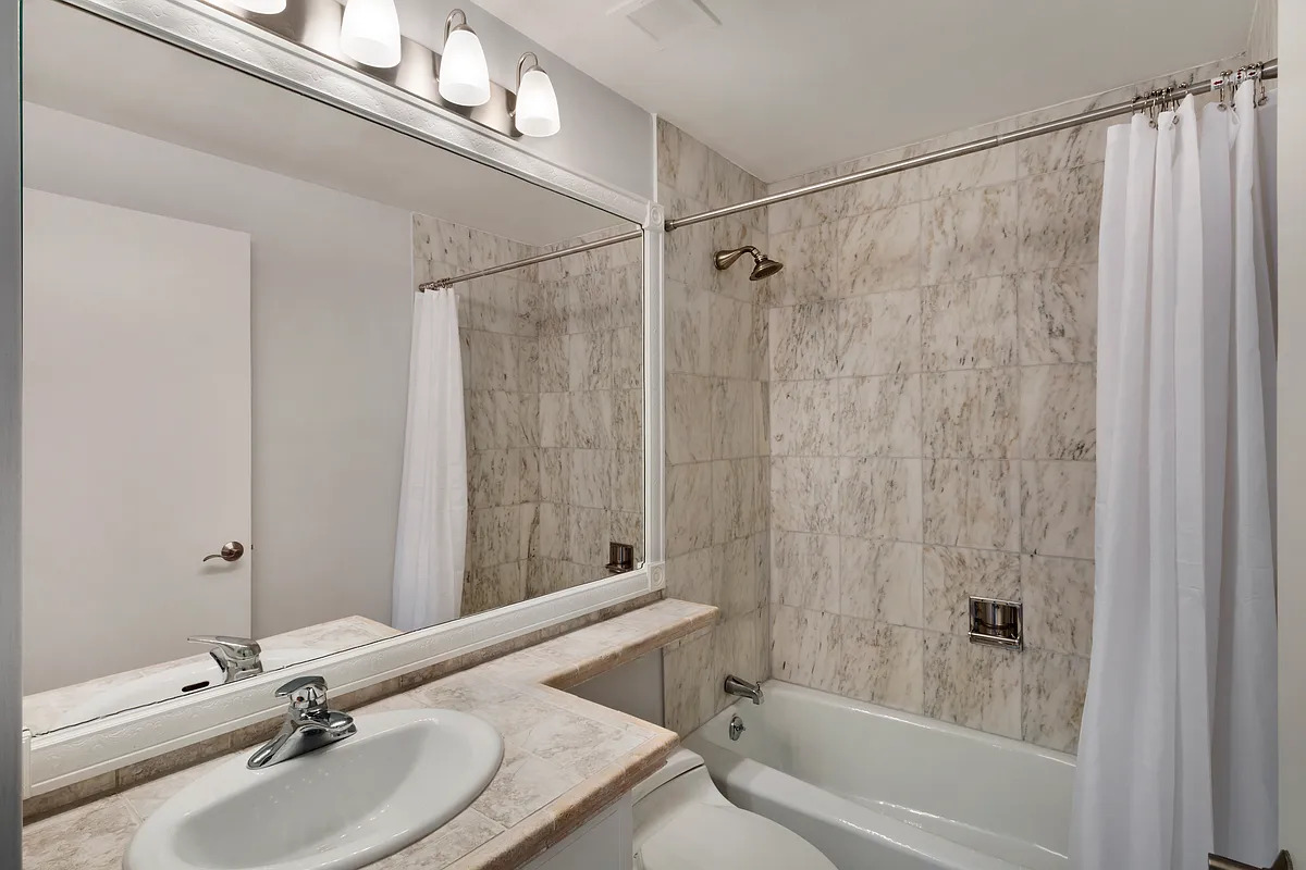 150 East 85th Street, Unit 11E Manhattan, NY 10028 - Photo 5 of 6 a bathroom with a sink and a mirror
