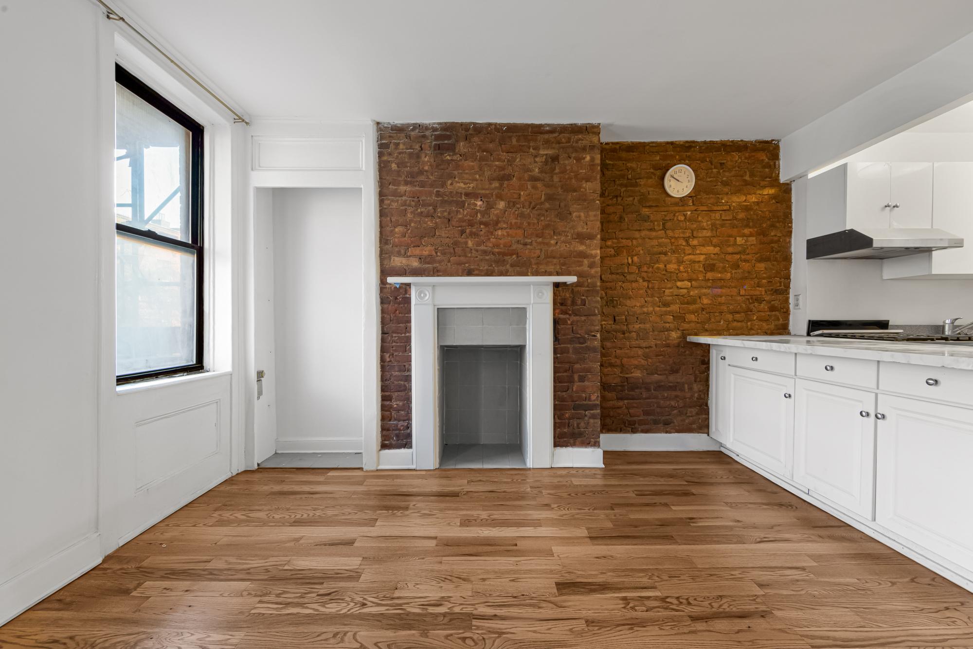 504 East 6th Street, Unit 6 Manhattan, NY 10009 - Photo 16 of 19 a view of a kitchen with wooden floor and a fireplace
