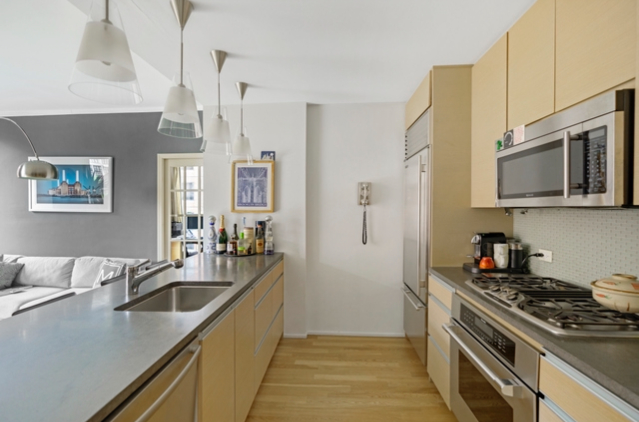 110 3rd Avenue, Unit 9B Manhattan, NY 10003 - Photo 3 of 14 a kitchen with stainless steel appliances a sink a stove and a refrigerator