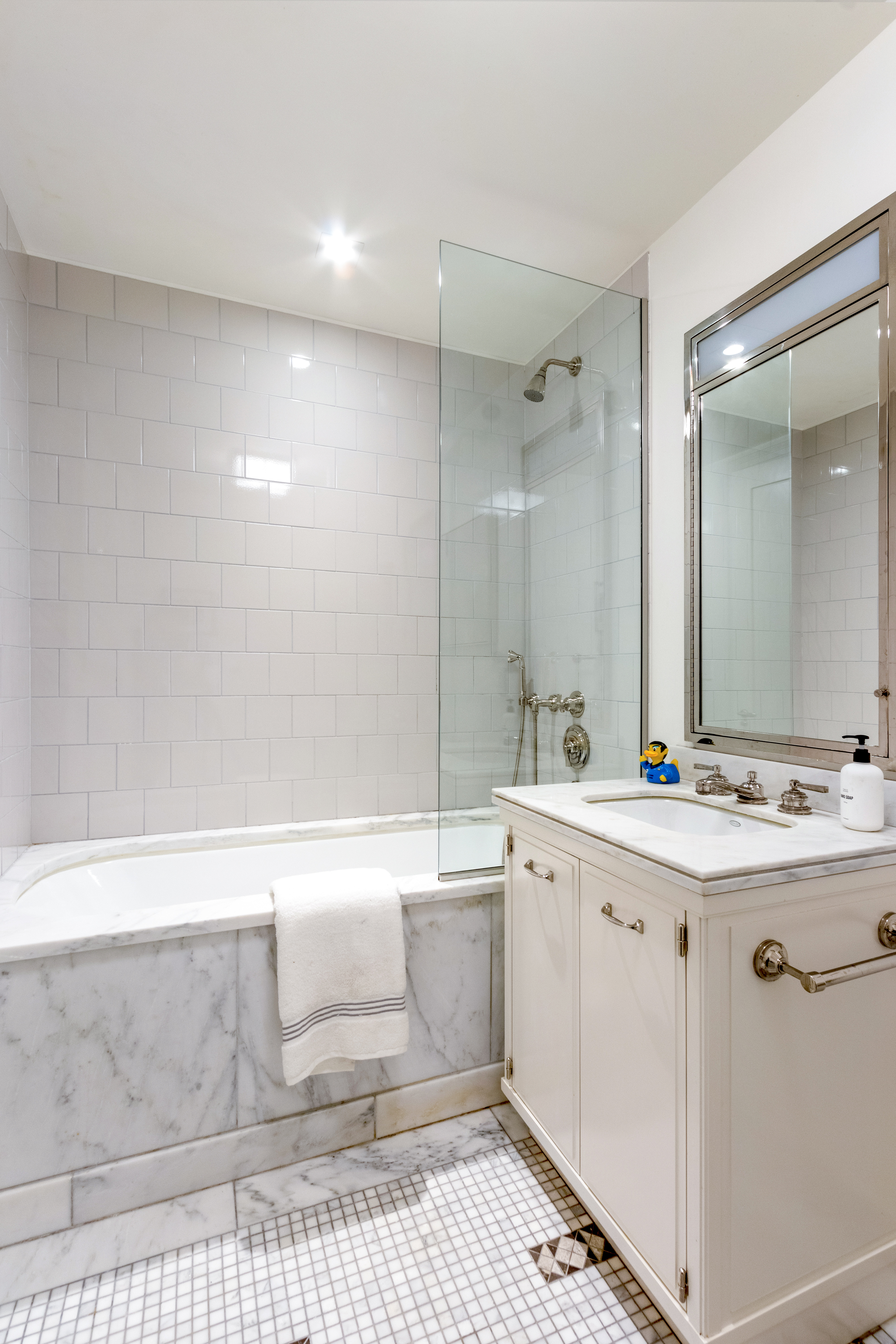 160 West 12th Street, Unit 56 Manhattan, NY 10011 - Photo 9 of 18 a spacious bathroom with a bathtub sink and mirror