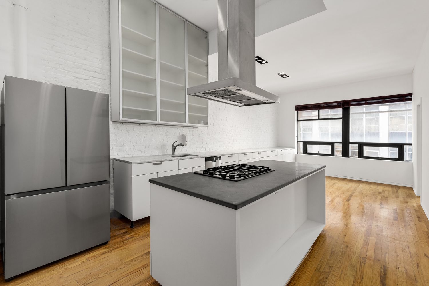 24 Beaver Street Manhattan, NY 10004 - Photo 16 of 25 a kitchen with a stove a refrigerator and wooden floor