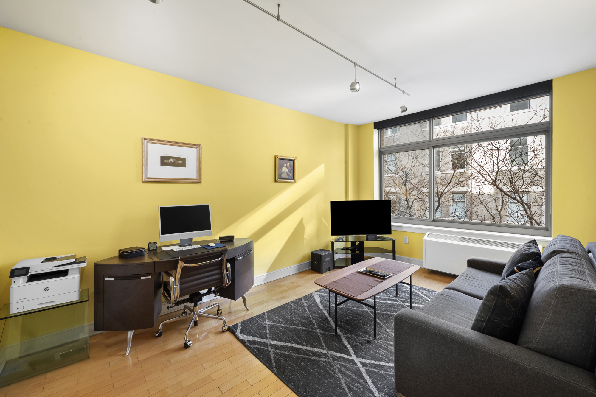 99 Jane Street, Unit 4H Manhattan, NY 10014 - Photo 13 of 22 a work room with furniture and a flat screen tv