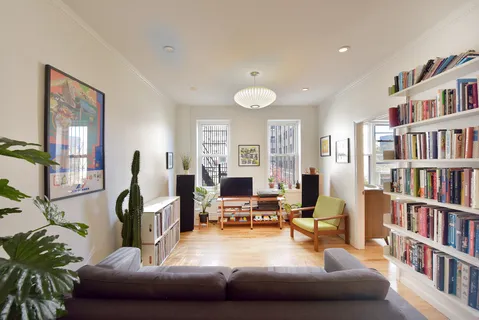 a living room with furniture and a book shelf