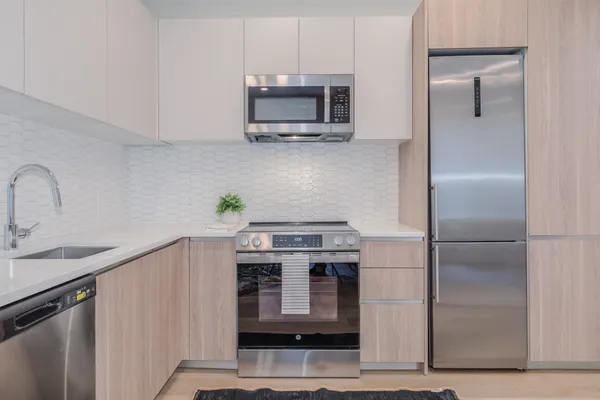 a kitchen with stainless steel appliances a stove a microwave and a sink