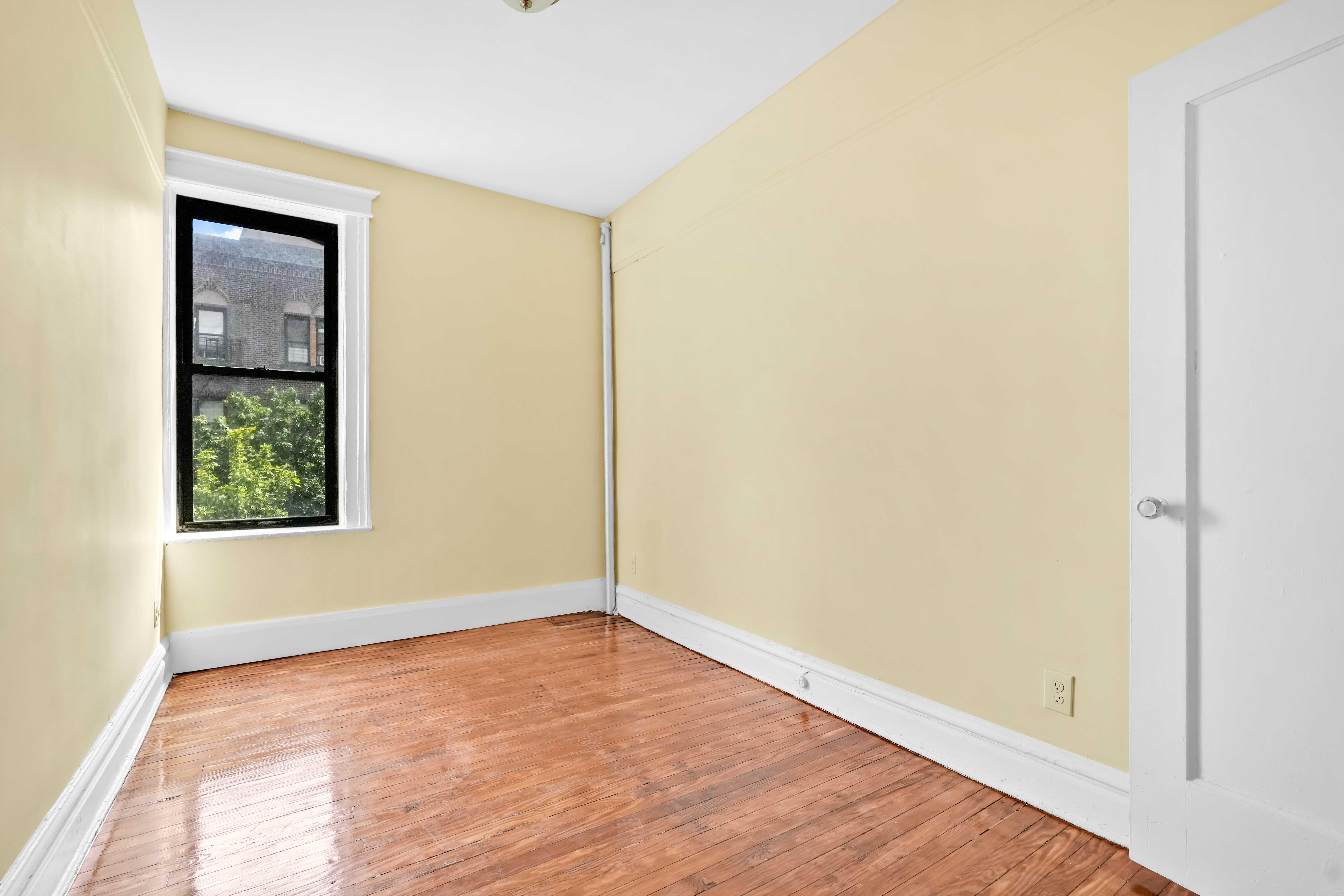 1770 Bedford Avenue Brooklyn, NY 11225 - Photo 24 of 50 an empty room with wooden floor and windows