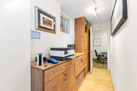 a hallway with a sink and cabinets