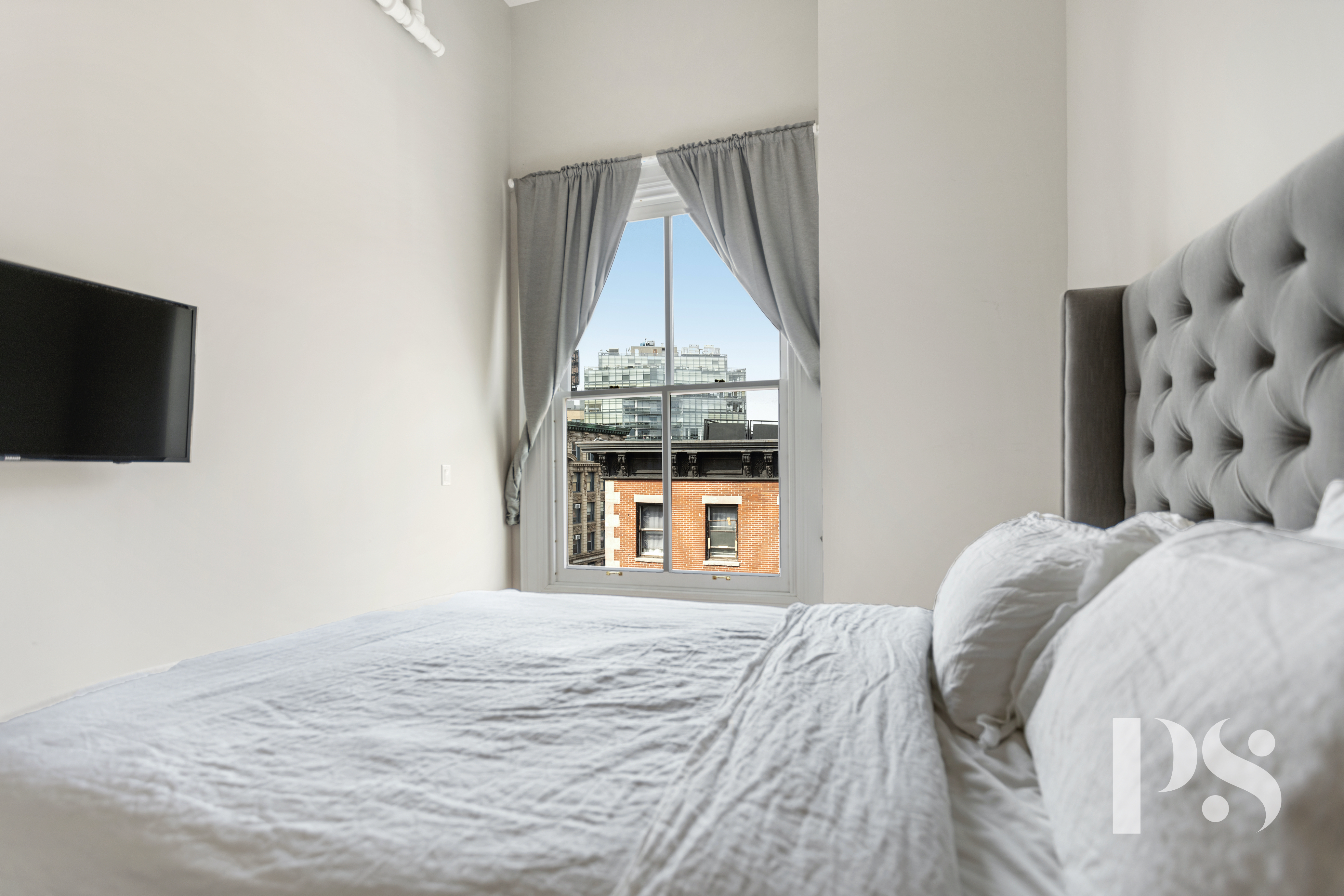 2 Wooster Street, Unit 5A Manhattan, NY 10013 - Photo 8 of 12 a bedroom with a bed and a flat screen tv