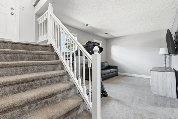 a front view of a building with a yard and car parked