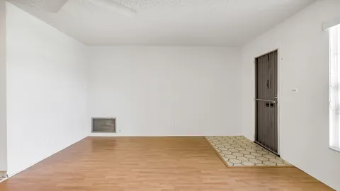 a view of an empty room and kitchen